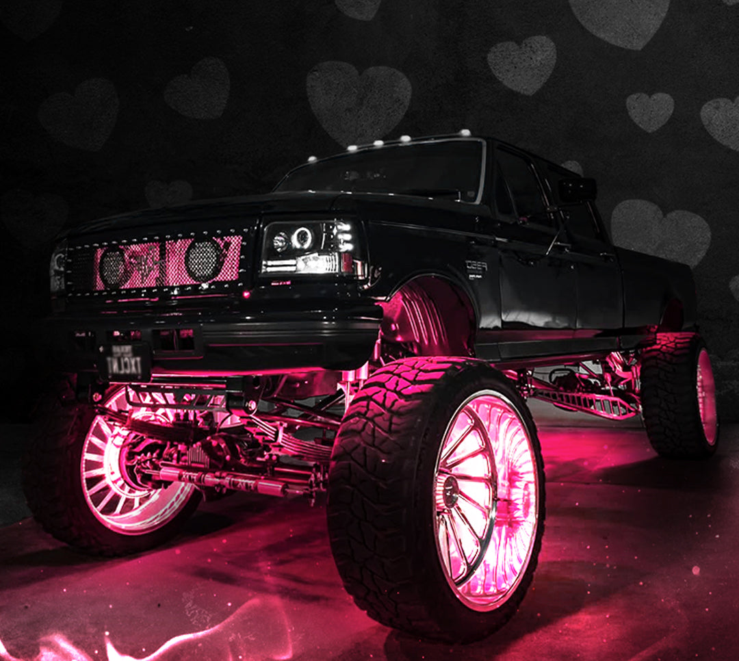 Black truck with pink LED lights on a dark background with heart shapes